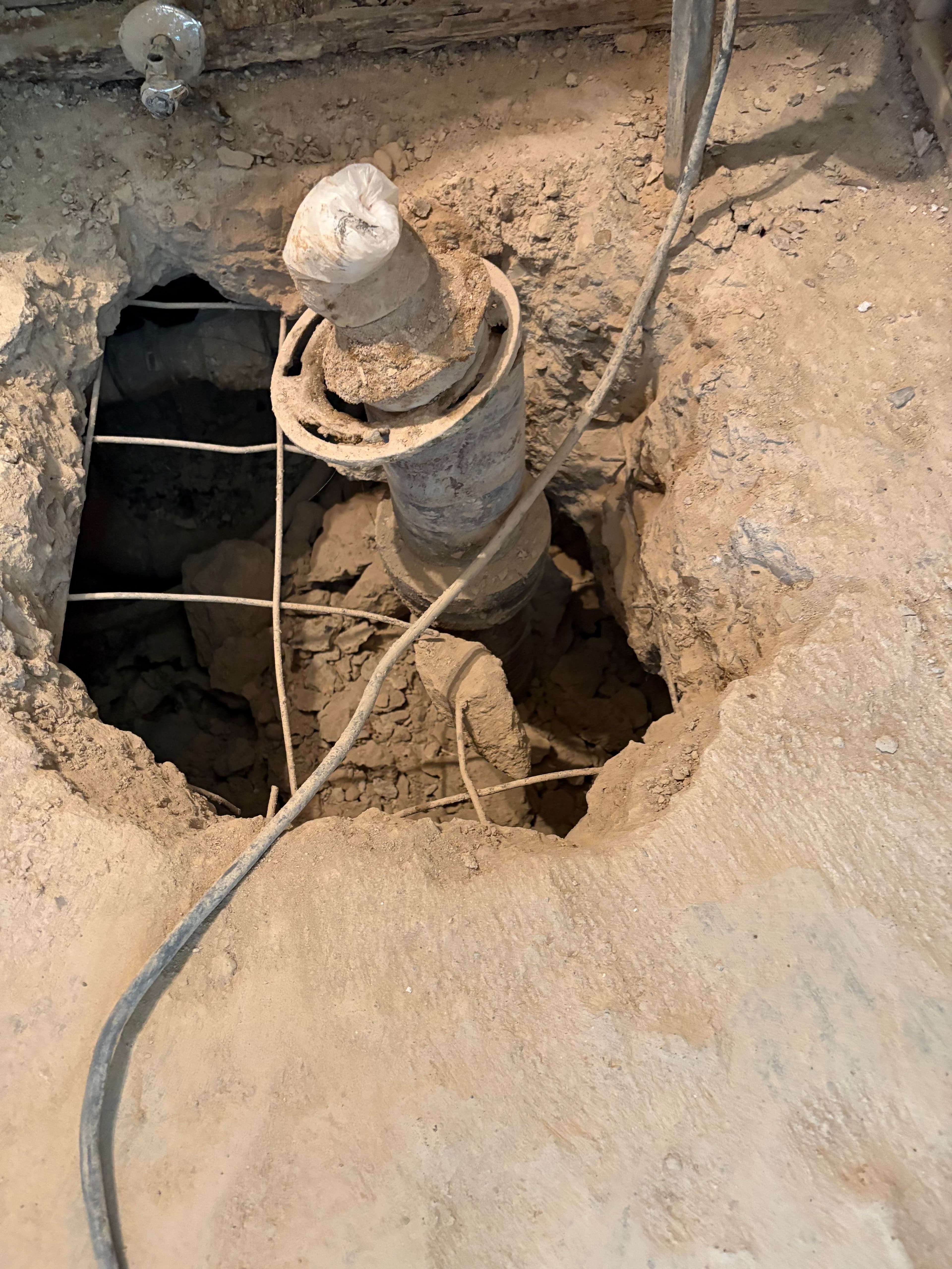 Hole cut in the concrete floor showing the drain and void space underneath